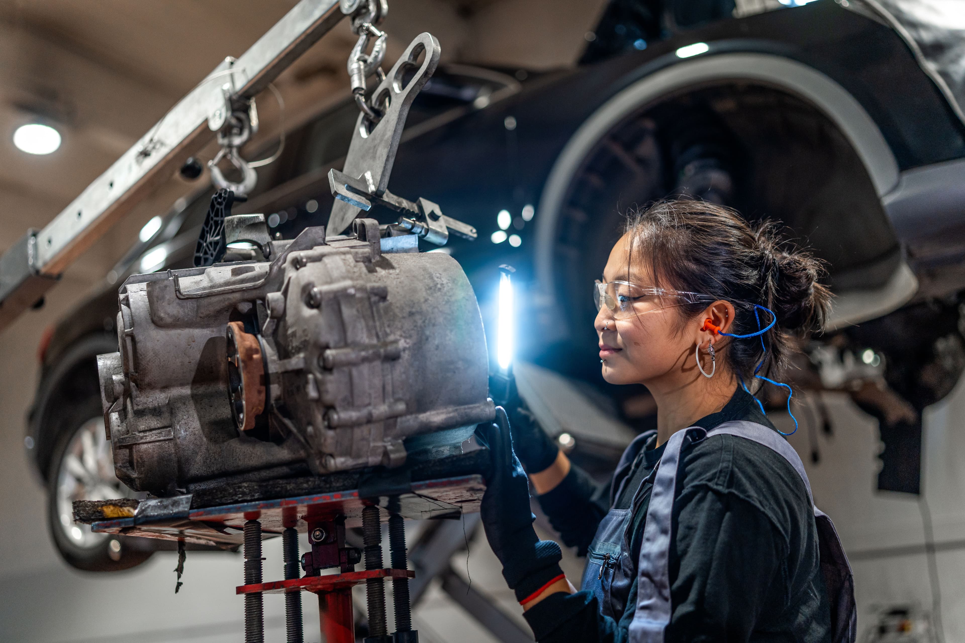 woman working on machinery wearing ear plugs