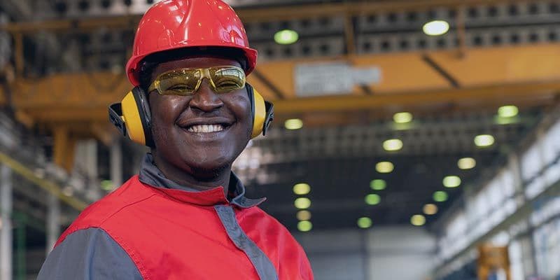 Man smiling in industrial hardhat with hearing protection